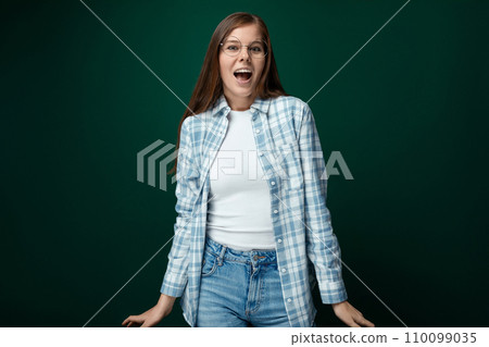 Cheerful woman dressed in a white turtleneck and shirt laughs on a green background Cheerful woman dressed in a white turtleneck and shirt laughs on a green background 110099035