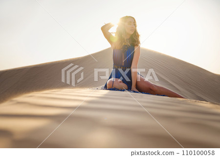 Woman in sands dunes of desert at sunset 110100058