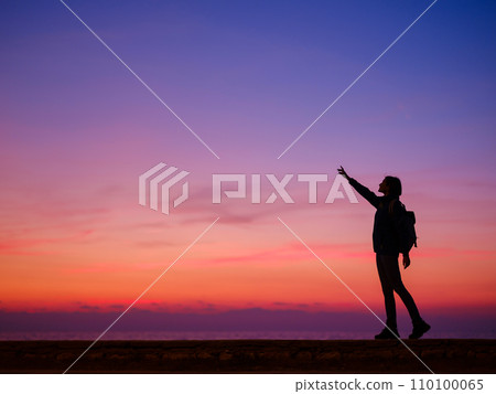 Woman tourist against sunset sky Woman tourist against sunset sky 110100065
