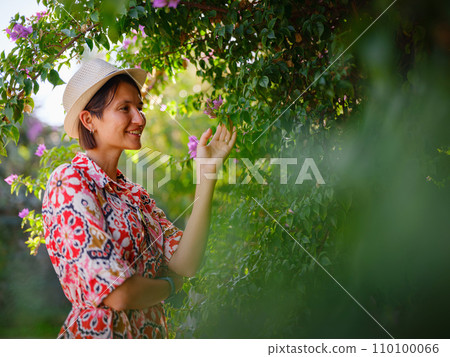 young woman stands in sunny green park young woman stands in sunny green park 110100066