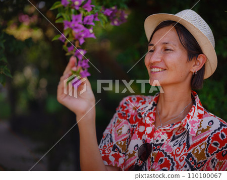young woman stands in sunny green park young woman stands in sunny green park 110100067