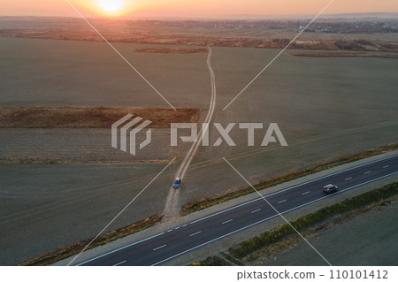 Aerial view of intercity road with fast driving cars at sunset. Top view from drone of highway traffic in evening Aerial view of intercity road with fast driving cars at sunset. Top view from drone of highway traffic in evening 110101412