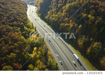 View from above of I-40 freeway route in North Carolina leading to Asheville thru Appalachian mountains with yellow fall woods and fast moving trucks and cars. Interstate transportation concept 110101455