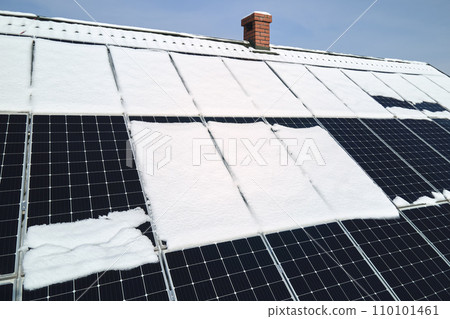 Aerial view of house roof with solar panels covered with snow melting down in winter end for producing clean energy. Concept of low effectivity of renewable electricity in northern region 110101461