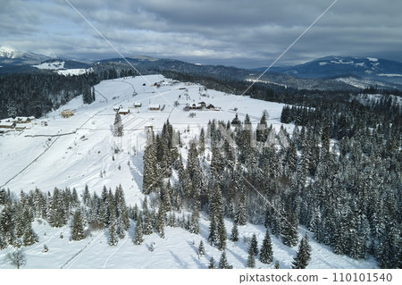 Winter landscape with small rural houses in remote settlement between snow covered forest in cold mountains 110101540