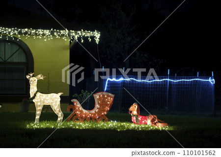 Front yard with brightly illuminated Christmas decorations. Outside decor of Florida family home for winter holidays Front yard with brightly illuminated Christmas decorations. Outside decor of Florida family home for winter holidays 110101562