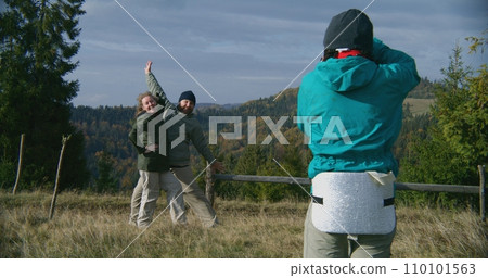 Young hiker takes pictures of Caucasian tourist family Young hiker takes pictures of Caucasian tourist family 110101563