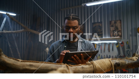 African American craftsman uses digital tablet computer 110101754