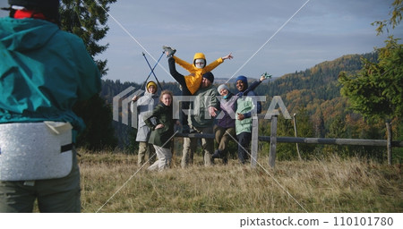 Teenage hiker takes pictures of his friends during hike in mountains 110101780