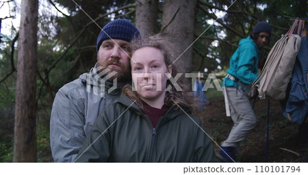 Caucasian young girl stands in the woods, smiles and looks at camera 110101794