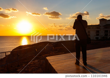 Young man taking a photos of the Red Sea at sunset in Sharm El Sheikh, Egypt Young man taking a photos of the Red Sea at sunset in Sharm El Sheikh, Egypt 110101946