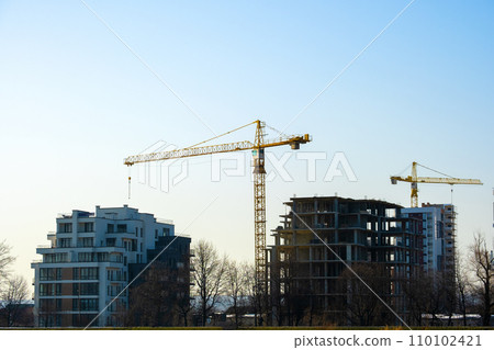 Aerial view of tower cranes and high residential apartment buildings under construction. Real estate development. Aerial view of tower cranes and high residential apartment buildings under construction. Real estate development. 110102421
