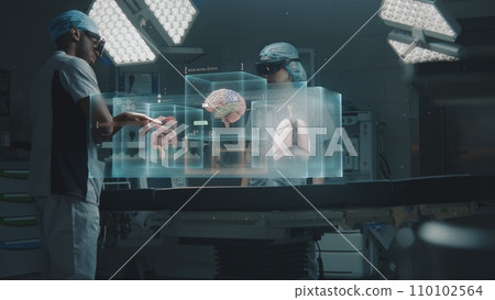 Multiethnic surgeons in AR headsets work in high-tech operating room Multiethnic surgeons in AR headsets work in high-tech operating room 110102564