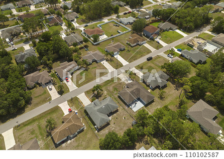 Aerial view of small town America suburban landscape with private homes between green palm trees in Florida quiet residential area Aerial view of small town America suburban landscape with private homes between green palm trees in Florida quiet residential area 110102587