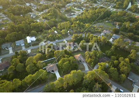 Aerial view of suburban landscape with private homes between green palm trees in Florida quiet residential area Aerial view of suburban landscape with private homes between green palm trees in Florida quiet residential area 110102631