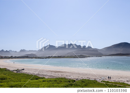 Couples stroll and swim at Jusnesvika Bay, Lofoten, under glistening skies 110103398