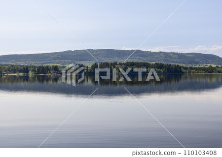 Calm Lake Snasa mirroring dense forests along its shores in scenic Steinkjer Calm Lake Snasa mirroring dense forests along its shores in scenic Steinkjer 110103408