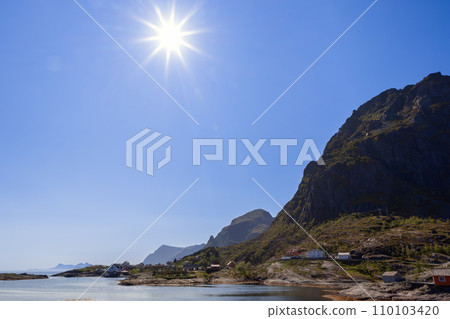 Bright summer sunrays illuminate Moskenes in the Lofoten Islands, Norway 110103420