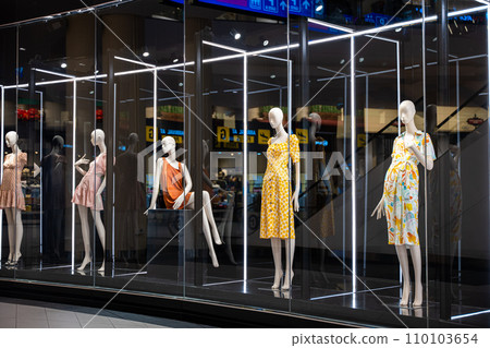 A display case full of mannequins showcasing diverse poses and styles for the fashion industry, Colorful and artistic mannequins in a store display case 110103654