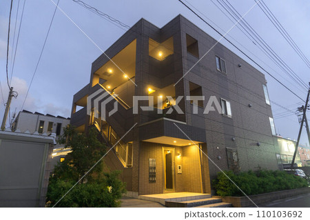 Evening apartment complex lights on Evening apartment complex lights on 110103692