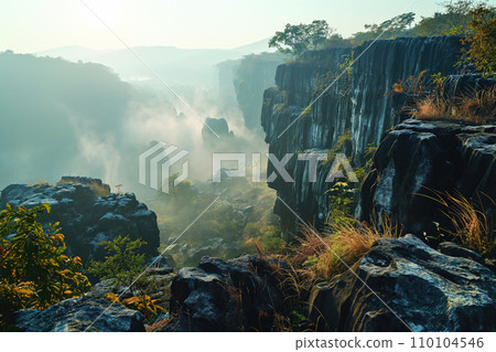 path in a mountainous area overlooking a beautiful misty valley in the morning rays 110104546