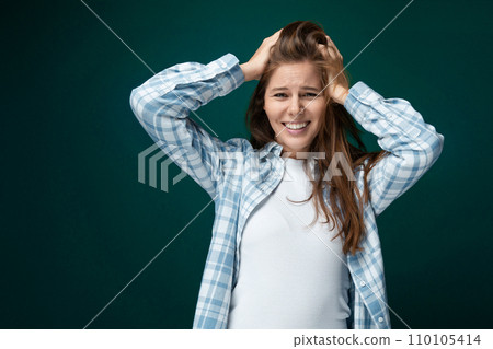 Confident Caucasian young woman with brown healthy hair on green studio background Confident Caucasian young woman with brown healthy hair on green studio background 110105414