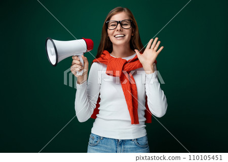 Young woman with brown hair dressed in a white turtleneck holding a loudspeaker, business concept 110105451