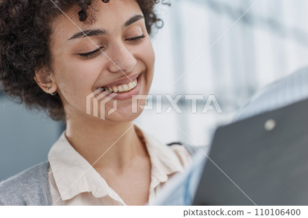 woman in the office looking through paper documents 110106400