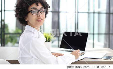 Portrait of Young Successful Caucasian Businesswoman Sitting at Desk Working on Laptop Portrait of Young Successful Caucasian Businesswoman Sitting at Desk Working on Laptop 110106403