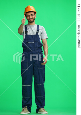 A builder male on a green background show the up sign A builder male on a green background show the up sign 110106614