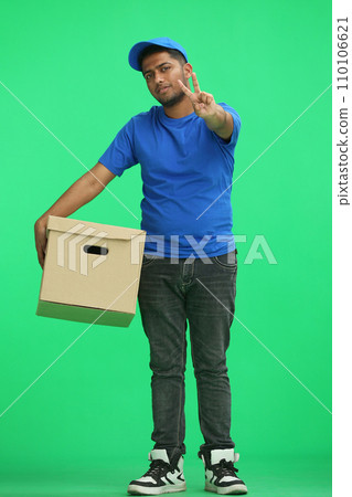 A man on a green background with box show a victory sign A man on a green background with box show a victory sign 110106621