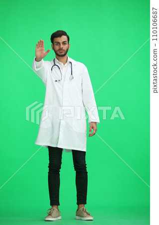 male doctor on a green background. shows stop sign male doctor on a green background. shows stop sign 110106687