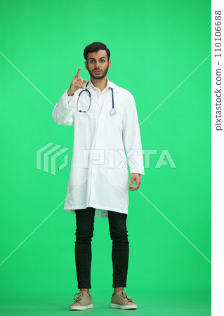 male doctor on a green background. shows a sign this is important male doctor on a green background. shows a sign this is important 110106688