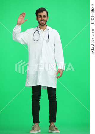 male doctor on a green background shows hello sign male doctor on a green background shows hello sign 110106689