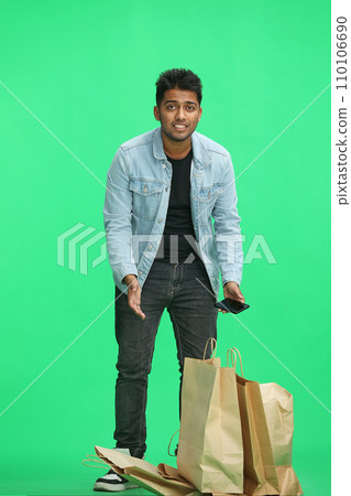 Man on a green background with shoppers Man on a green background with shoppers 110106690