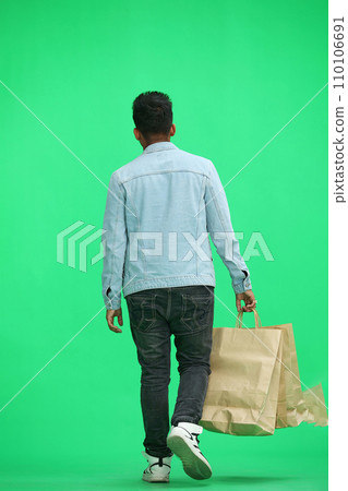 Man on a green background with shoppers Man on a green background with shoppers 110106691