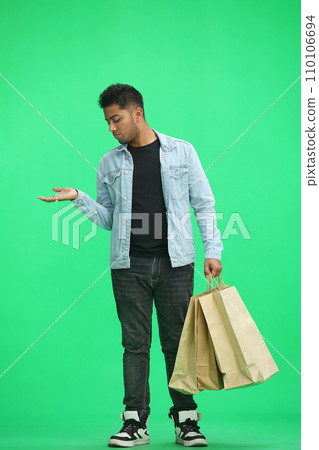 Man on a green background with shoppers point side Man on a green background with shoppers point side 110106694