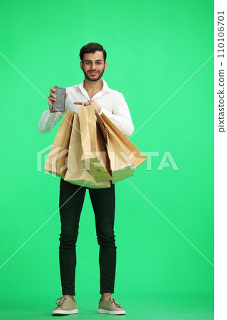 Man on a green background with shoppers and phone 110106701