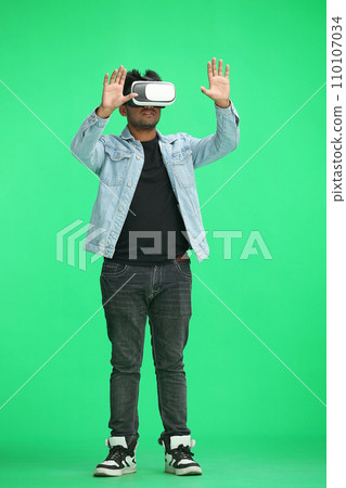 full-length man on a green background wearing 3D augmented reality glasses 110107034