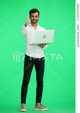 man on a green background. uses a computer, and show like sign 110107080