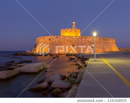 Old stone lighthouse in Fort St. Nicholas in Rhodes at sunset. Old stone lighthouse in Fort St. Nicholas in Rhodes at sunset. 110108035