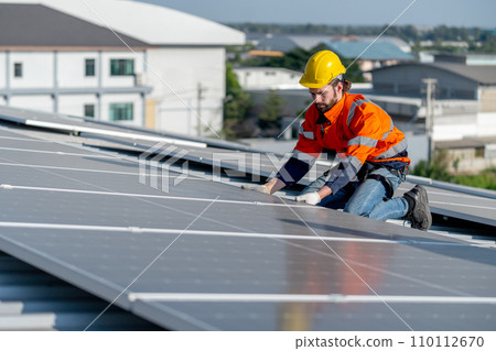 One of industrial technician worker hold the panel after install to maintenance solar cell panels on rooftop of factory building. Green and sustainable energy concept to good environment. One of industrial technician worker hold the panel after install to maintenance solar cell panels on rooftop of factory building. Green and sustainable energy concept to good environment. 110112670