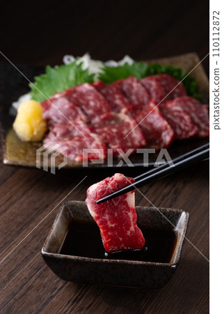 Eating horse sashimi with chopsticks 110112872