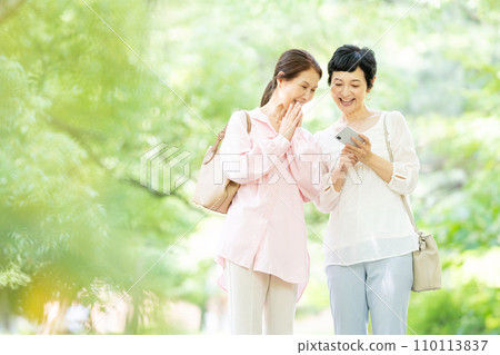 A middle-aged woman taking a commemorative photo with a smartphone 110113837