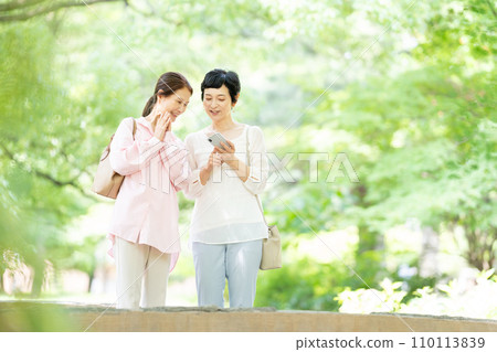 A middle-aged woman taking a commemorative photo with a smartphone 110113839