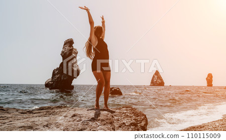 Woman summer travel sea. Happy tourist in hat enjoy taking picture outdoors for memories. Woman traveler posing on the beach at sea surrounded by volcanic mountains, sharing travel adventure journey 110115009