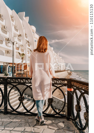 Woman summer travel sea. Happy tourist enjoy taking picture outdoors for memories. Carefree woman traveler posing on beach at sea on sunset, sharing travel adventure journey. Holiday vacation concept. 110115130