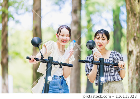 A woman who hydrates on an electric kickboard 110115328