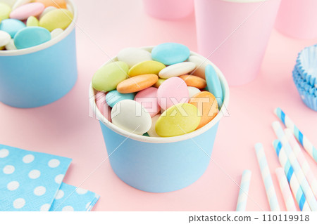 Traditional Easter Portuguese candies. Colorful Sweets in a blue paper cup on pink background Traditional Easter Portuguese candies. Colorful Sweets in a blue paper cup on pink background 110119918