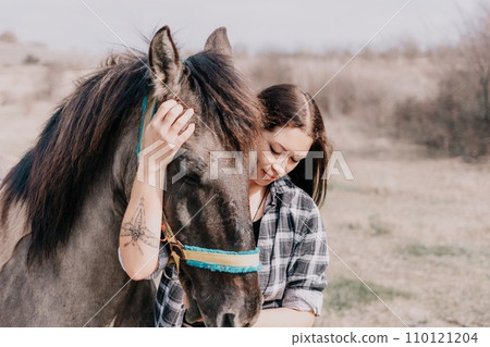 Young happy woman with her pony horse in evening sunset light. Outdoor photography with fashion model girl. Lifestyle mood. Concept of outdoor riding, sports and recreation. Young happy woman with her pony horse in evening sunset light. Outdoor photography with fashion model girl. Lifestyle mood. Concept of outdoor riding, sports and recreation. 110121204